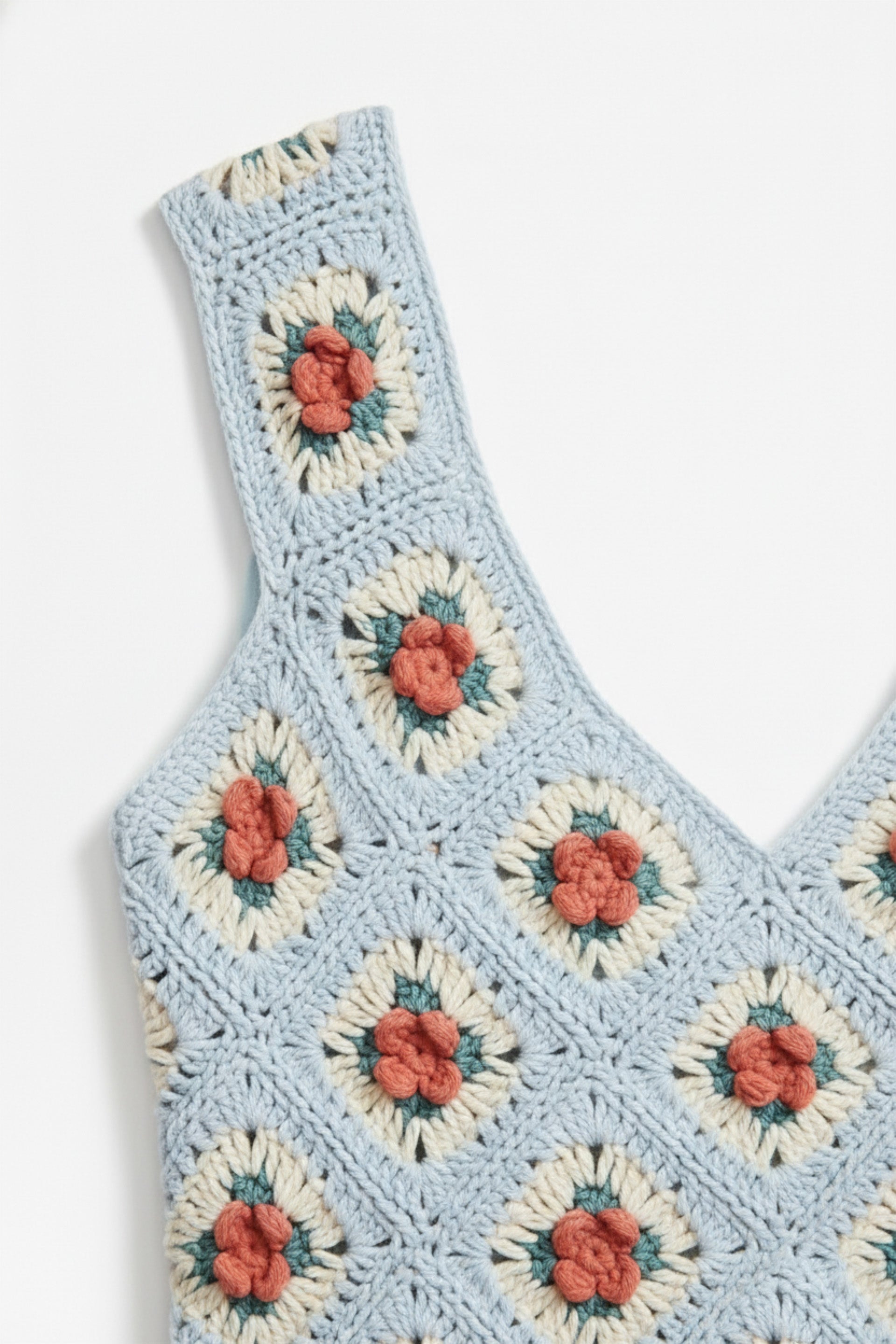 Crocheted top with floral patterns on a white background