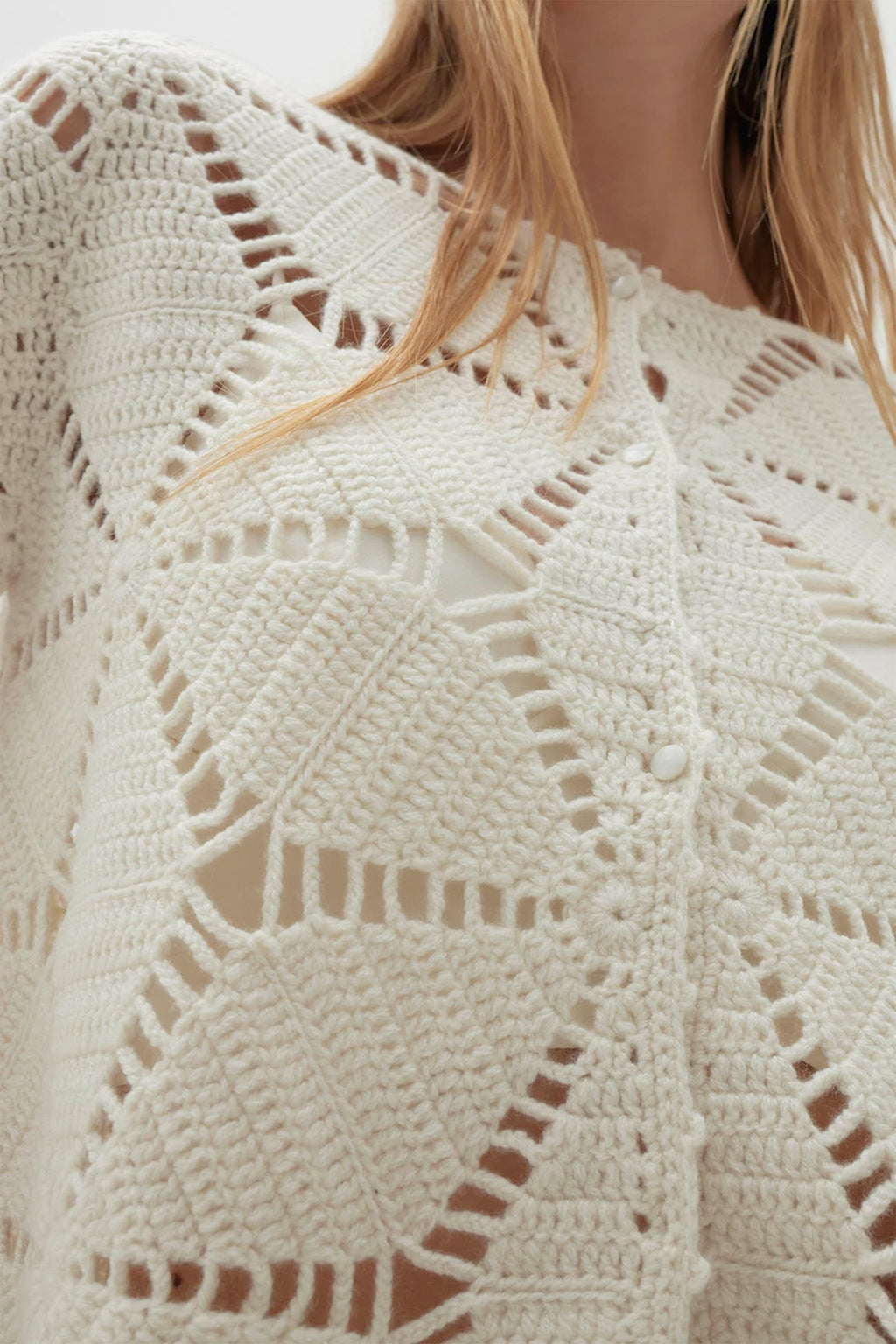 Close-up of a cream-colored crochet garment with geometric pattern